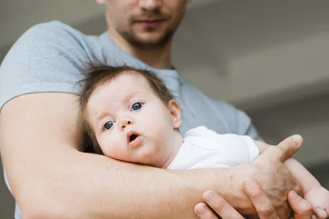 bebe-tendido-manos-padre